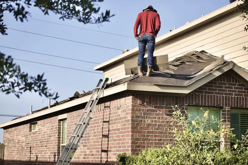 Professional roofer working on a residential roof in Hewlett Harbor